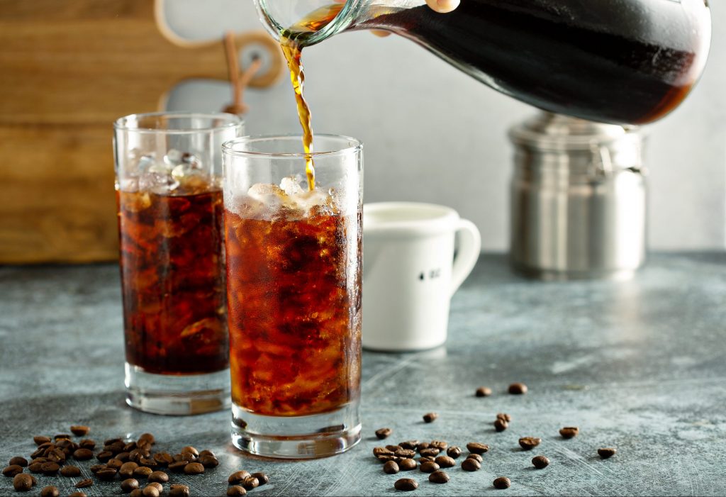 fresh cold brew coffee being poured in tall glasses