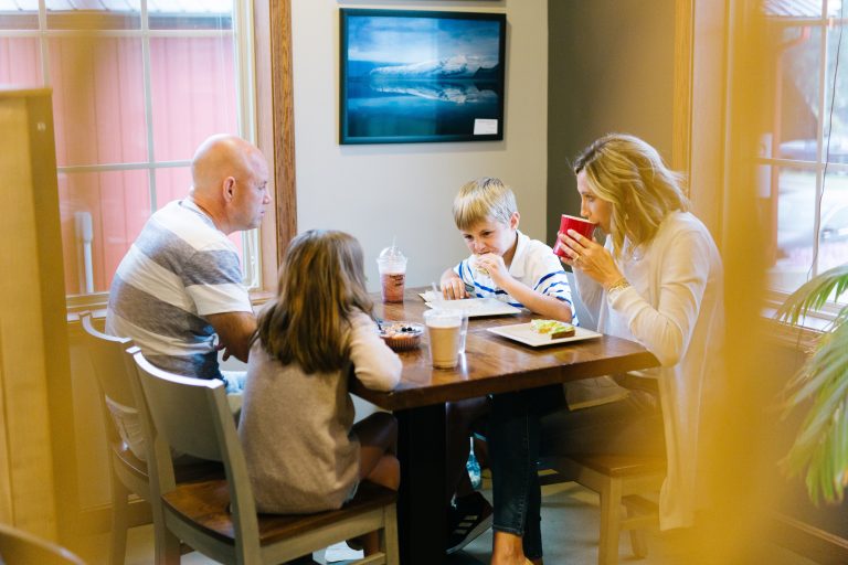 family enjoying coffee and food at a table