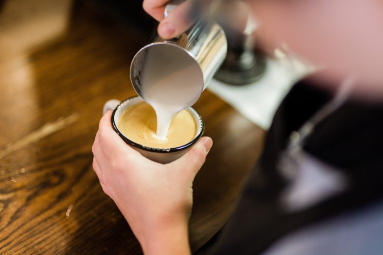 milk being poured in a latte